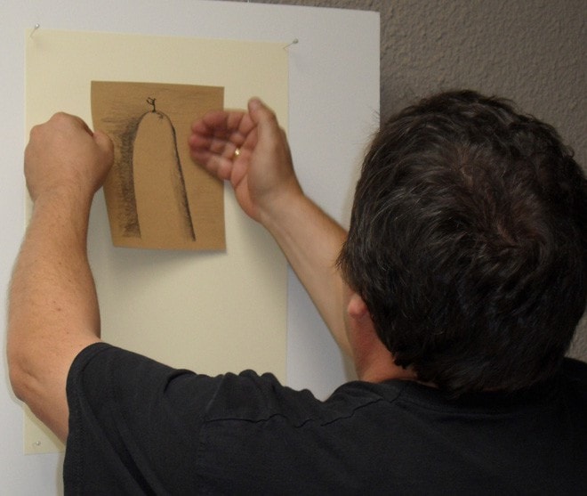 El autor se dispone a pegar en la instalación el dibujo (Diego Álvarez)