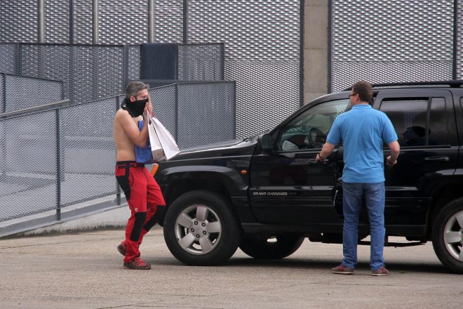 hombre sale del interior de las instalaciones en llamas de la fábrica de Embutidos Rodríguez, en Soto de la Vega (León), protegiéndose del humo con una tela (Peio García) 