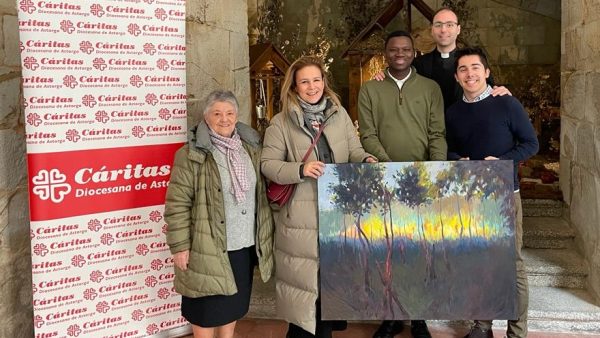 La directora de Cáritas Astorga, Inamculada del Peso, hace entrega del cuadro al rector del Seminario, Luis Fernández Olivares, en un acto que contó también con la representante del Banco Santander, Sandra González, y dos seminaristas