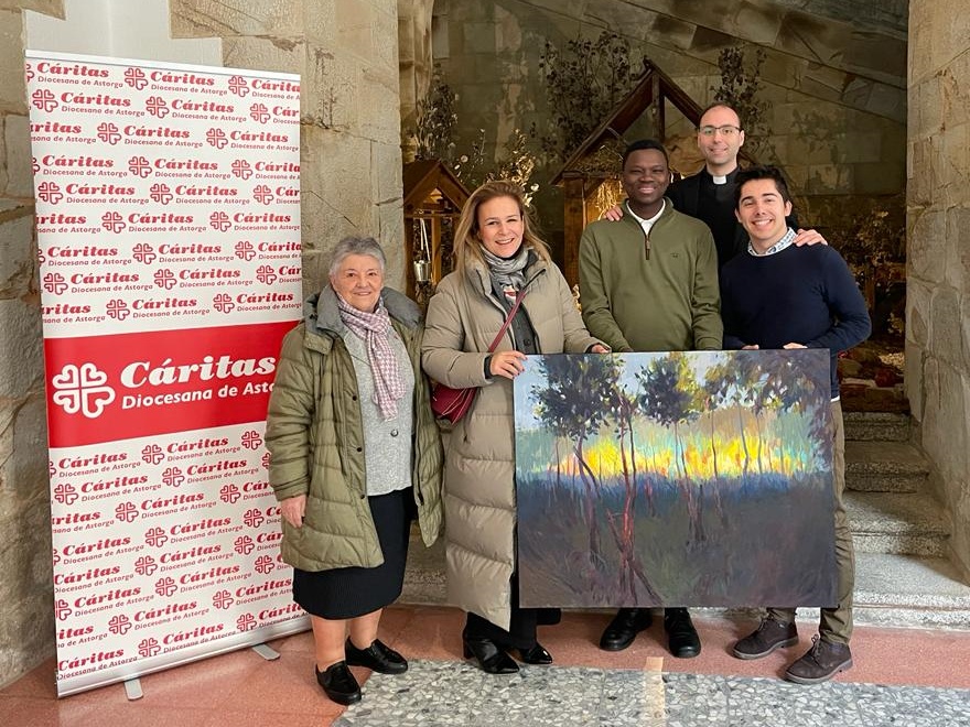 La directora de Cáritas Astorga, Inamculada del Peso, hace entrega del cuadro al rector del Seminario, Luis Fernández Olivares, en un acto que contó también con la representante del Banco Santander, Sandra González, y dos seminaristas